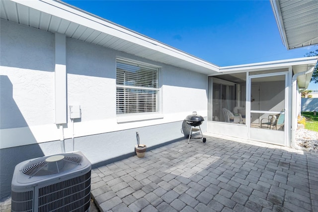 view of patio / terrace featuring a sunroom and cooling unit