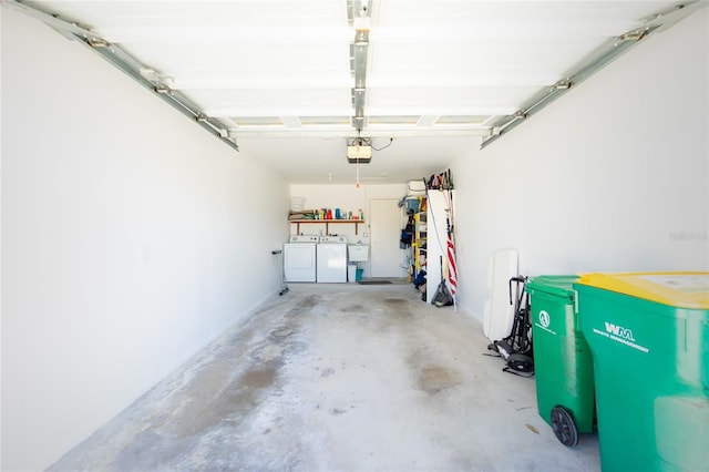 garage with a garage door opener and independent washer and dryer