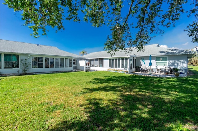 back of property featuring a sunroom, a yard, and a patio