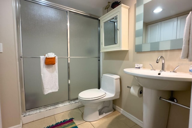 bathroom featuring toilet, sink, tile patterned flooring, and walk in shower