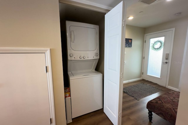 laundry area with dark hardwood / wood-style floors and stacked washer / dryer