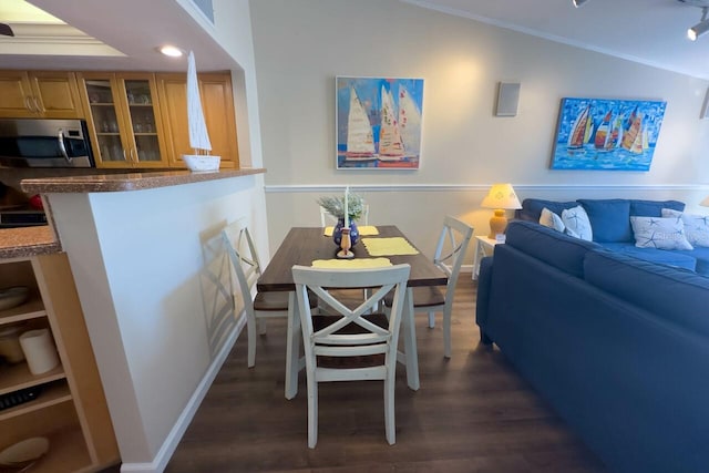 dining area featuring crown molding, dark hardwood / wood-style flooring, and lofted ceiling