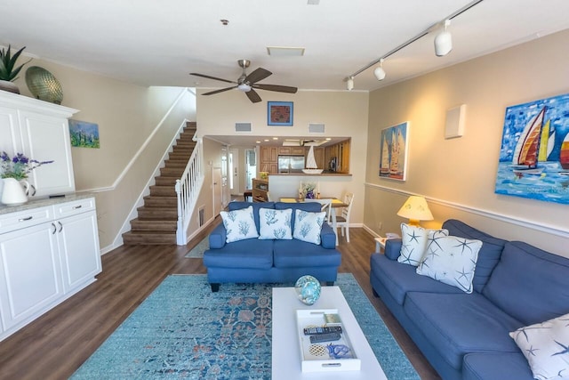 living room with track lighting, ceiling fan, and dark wood-type flooring