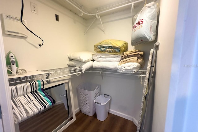 walk in closet with dark wood-type flooring