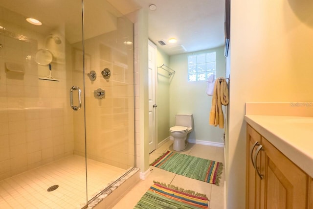 bathroom featuring tile patterned floors, vanity, toilet, and a shower with door