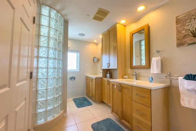 bathroom with a shower, tile patterned flooring, and vanity