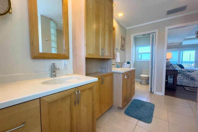 bathroom with tile patterned floors, vanity, toilet, and ornamental molding