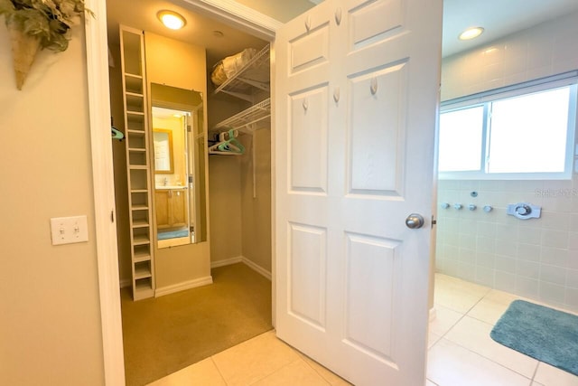 walk in closet featuring light tile patterned flooring