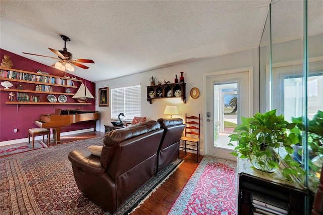 living room featuring dark hardwood / wood-style floors, ceiling fan, a textured ceiling, and vaulted ceiling