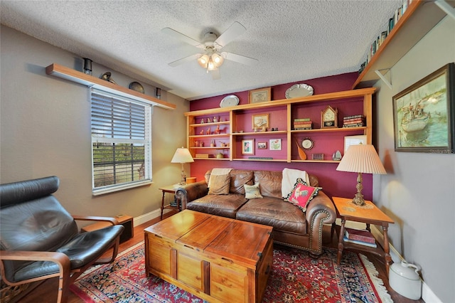 living room with wood-type flooring, a textured ceiling, and ceiling fan