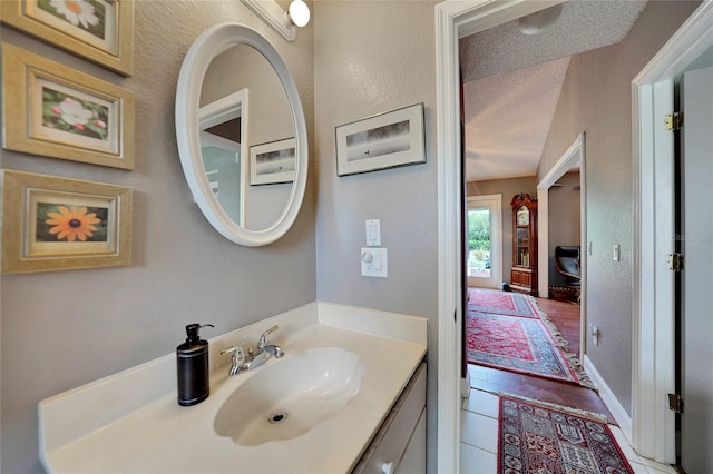 bathroom with hardwood / wood-style flooring, vanity, and a textured ceiling