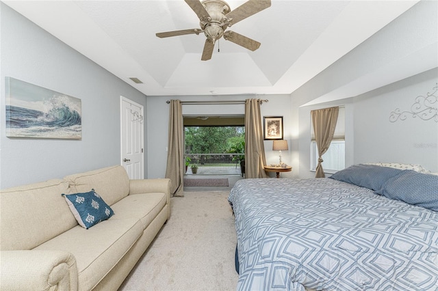 bedroom featuring visible vents, light colored carpet, a raised ceiling, a ceiling fan, and access to outside