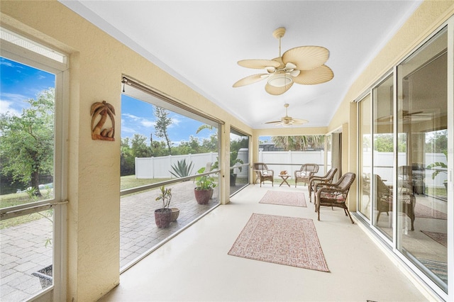 sunroom / solarium featuring plenty of natural light, ceiling fan, and vaulted ceiling