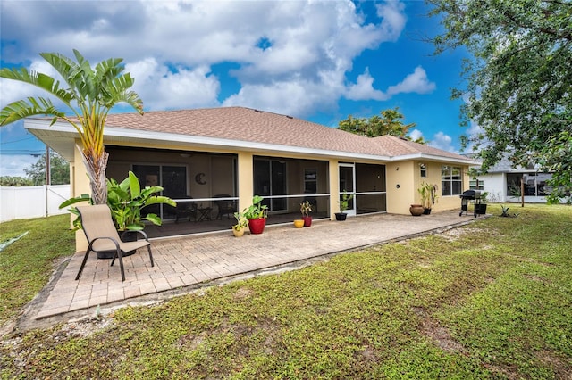 rear view of property with a yard, fence, a sunroom, and stucco siding