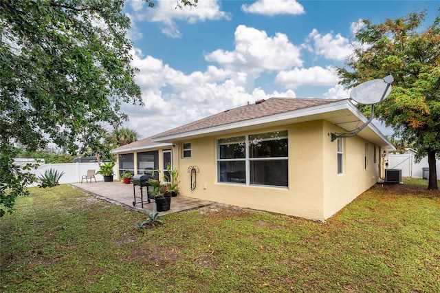 back of house with stucco siding, a lawn, a fenced backyard, and a patio area