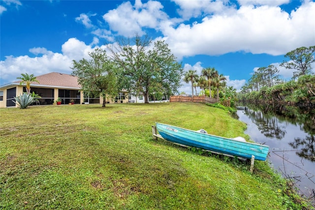 view of yard featuring a water view and a sunroom