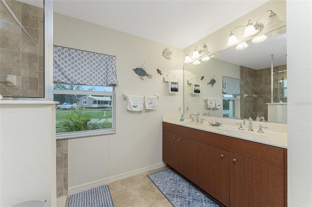 bathroom with double vanity, baseboards, walk in shower, and a sink