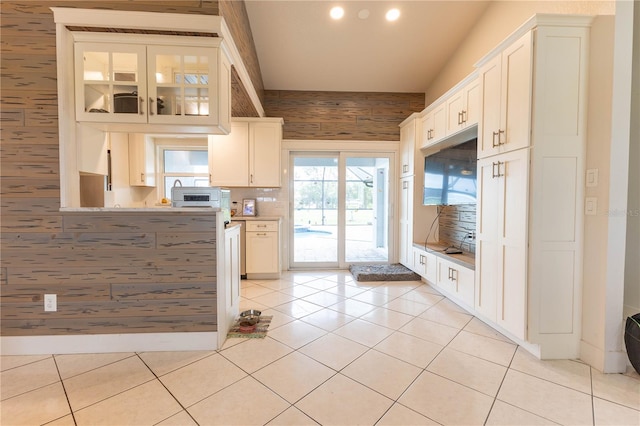 kitchen with white cabinets, light tile patterned floors, and backsplash