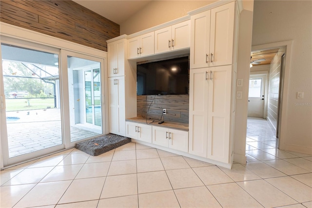 unfurnished living room featuring ceiling fan, a healthy amount of sunlight, and light tile patterned flooring