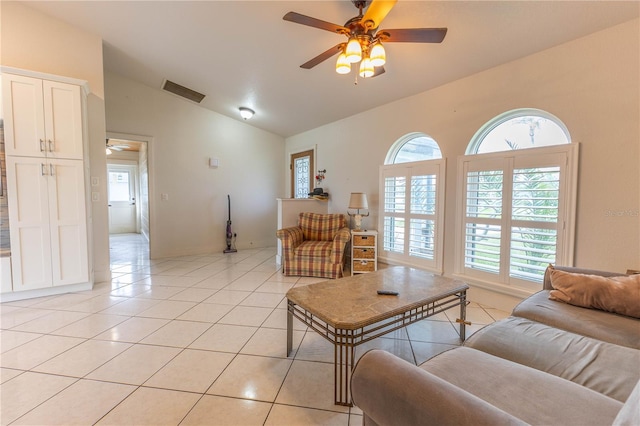 tiled living room featuring lofted ceiling, ceiling fan, and a healthy amount of sunlight