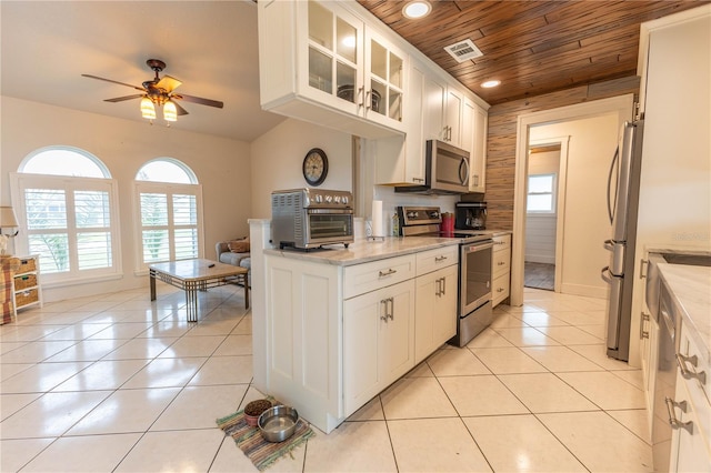 kitchen with white cabinets, wood ceiling, light tile patterned floors, and appliances with stainless steel finishes