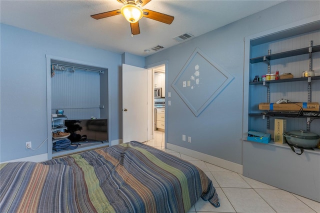 tiled bedroom featuring ceiling fan and a closet