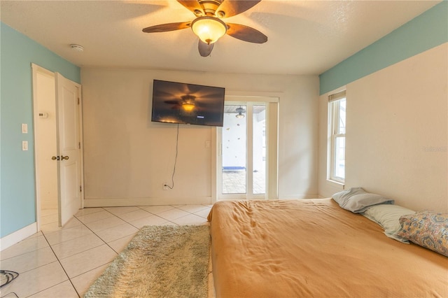 unfurnished bedroom with multiple windows, ceiling fan, light tile patterned flooring, and a textured ceiling