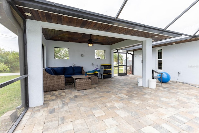 sunroom with a tray ceiling, ceiling fan, and wooden ceiling