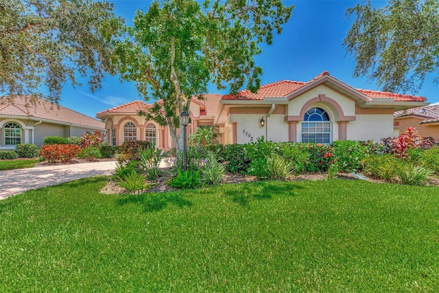 mediterranean / spanish-style house featuring a front lawn