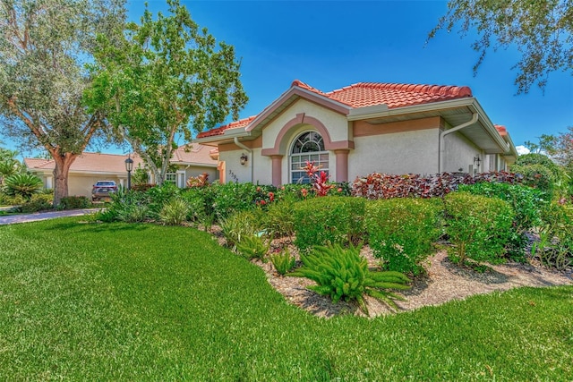 mediterranean / spanish home with a front lawn