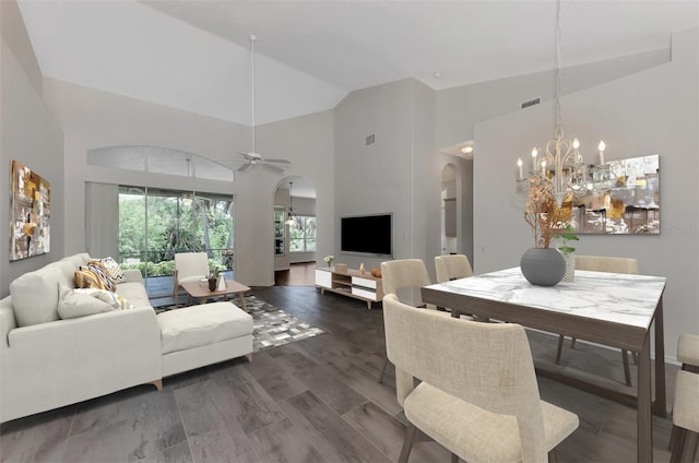 dining area with dark hardwood / wood-style floors, ceiling fan with notable chandelier, and high vaulted ceiling