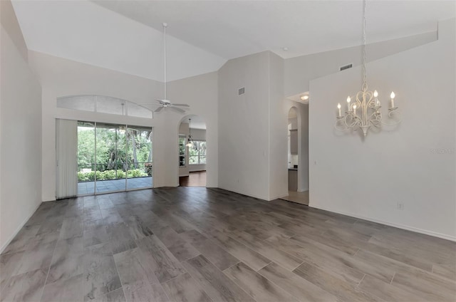 unfurnished living room with wood-type flooring, ceiling fan with notable chandelier, and high vaulted ceiling