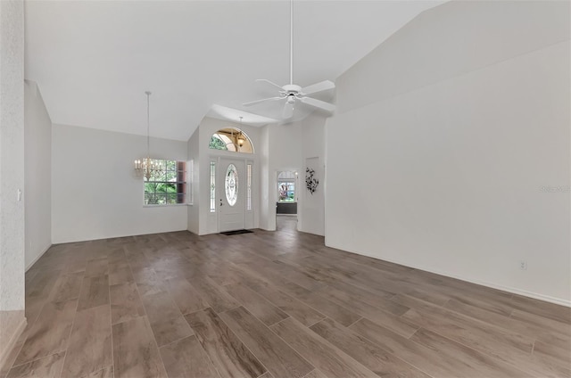 foyer with ceiling fan with notable chandelier, wood-type flooring, and high vaulted ceiling