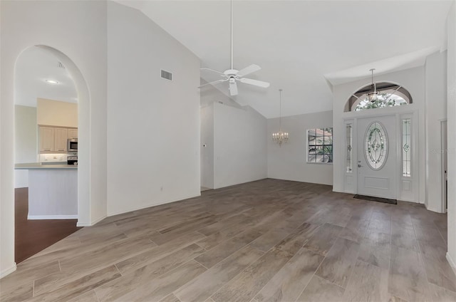 entryway featuring high vaulted ceiling, ceiling fan with notable chandelier, and light wood-type flooring