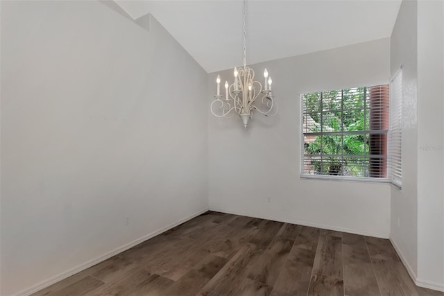 spare room featuring dark hardwood / wood-style floors, lofted ceiling, and a chandelier