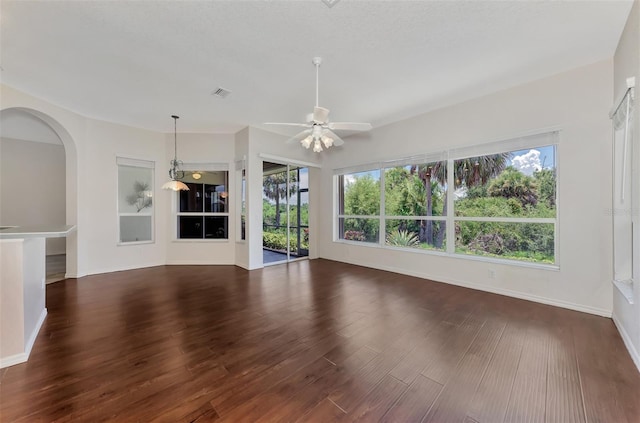 unfurnished living room featuring dark hardwood / wood-style flooring and ceiling fan