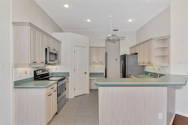 kitchen with ceiling fan, stainless steel appliances, kitchen peninsula, decorative backsplash, and light tile patterned flooring