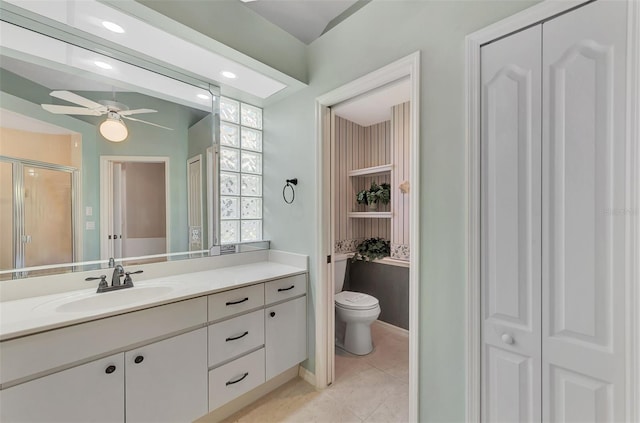 bathroom with vanity, a shower with door, ceiling fan, tile patterned flooring, and toilet