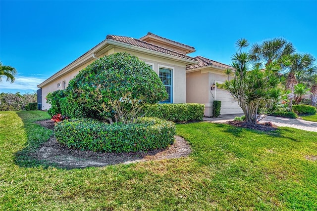 view of side of home featuring a lawn and a garage