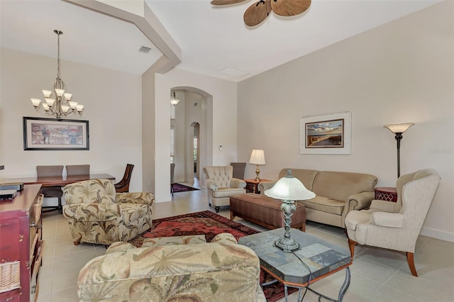 tiled living room with ceiling fan with notable chandelier