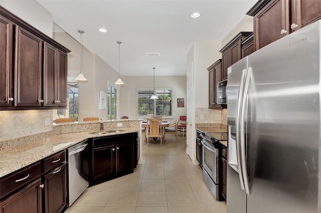 kitchen featuring backsplash, sink, hanging light fixtures, light tile patterned flooring, and stainless steel appliances