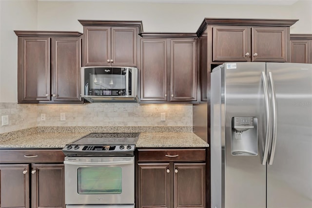 kitchen with light stone counters, dark brown cabinetry, and stainless steel appliances