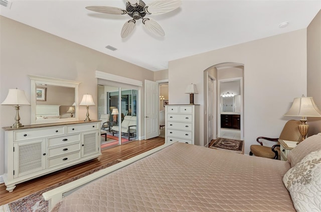 bedroom with hardwood / wood-style flooring, ceiling fan, and ensuite bathroom