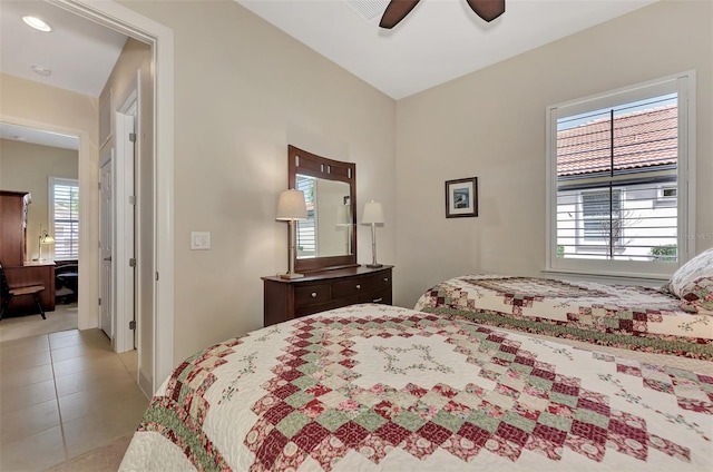 bedroom with multiple windows, light tile patterned floors, and ceiling fan