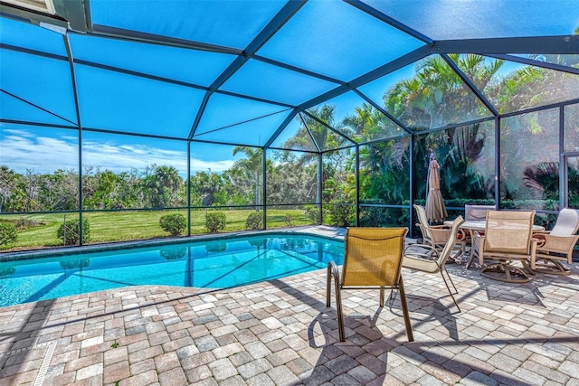 view of pool with glass enclosure and a patio