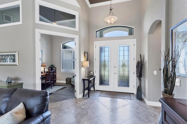 foyer entrance featuring french doors, a wealth of natural light, and a high ceiling