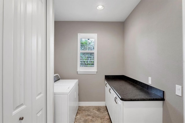 clothes washing area with cabinets and washing machine and dryer