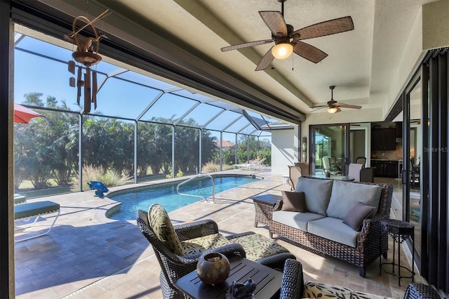 view of pool with outdoor lounge area, glass enclosure, ceiling fan, and a patio area