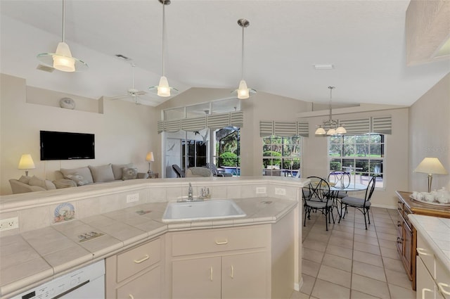 kitchen featuring ceiling fan, sink, white dishwasher, lofted ceiling, and light tile patterned flooring