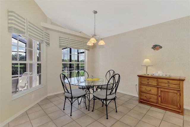 tiled dining space with lofted ceiling and a chandelier